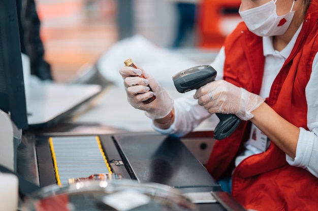 Una donna legge il codice a barre alla cassa del supermercato