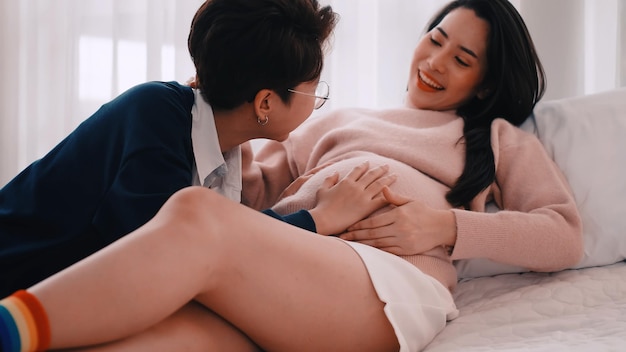 Una donna lesbica asiatica incinta e il suo partner sono felici di trascorrere del tempo insieme a casa.