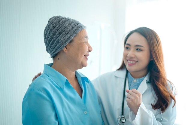 Una donna malata di cancro che indossa sciarpa per la testa dopo aver consultato la chemioterapia e in visita dal medico in ospedale