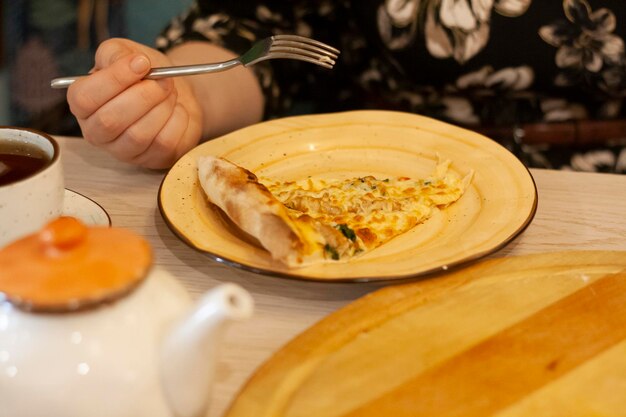 Una donna mangia la pizza con la forchetta