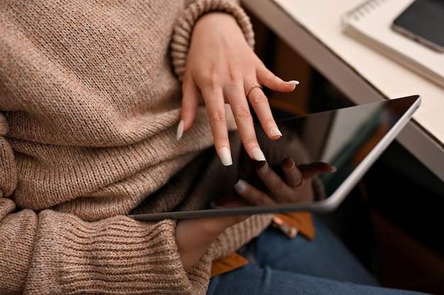 Una donna millenaria si rilassa nel suo spazio di lavoro in ufficio utilizzando il touchpad del tablet digitale