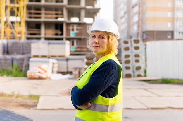 Una donna muratrice in un cantiere ispeziona un edificio