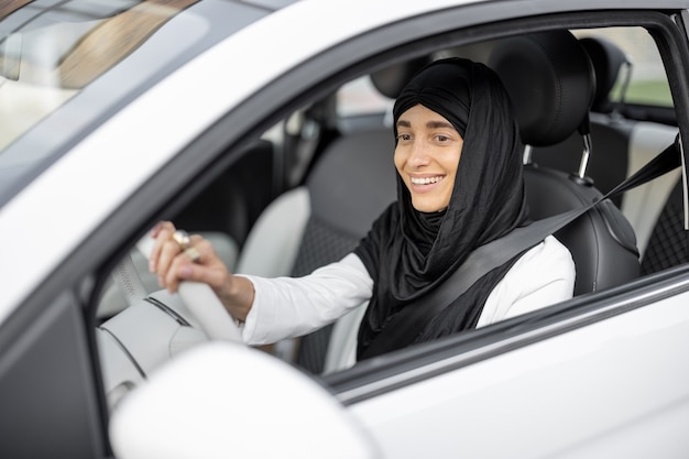 Una donna musulmana guida un'auto