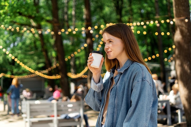 Una donna nel parco beve il caffè con se stessa