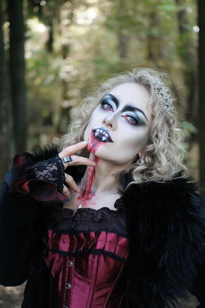 Una donna nell'immagine di un vampiro o di una strega con trucco e abiti medievali