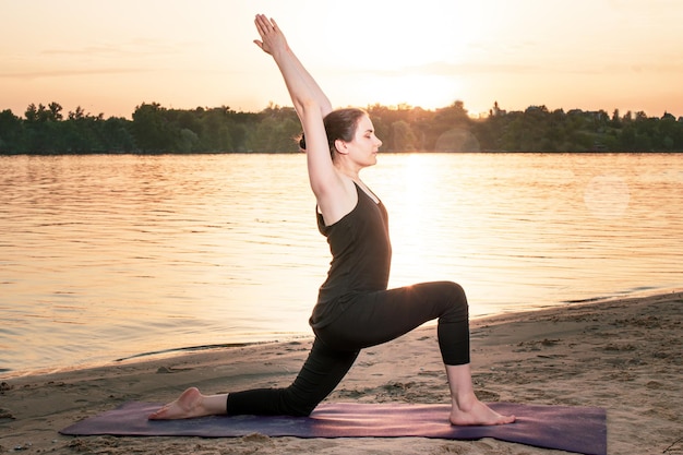 Una donna pratica lo yoga vicino al fiume.