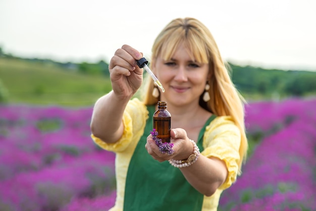 Una donna raccoglie fiori di lavanda per olio essenziale Messa a fuoco selettiva