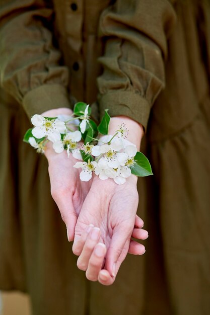 Una donna registrata con fiori di scotch tra le mani rappresenta una primavera rubata in Ucraina a causa della guerra Collegamento con la natura Natura e vita sostenibile Ferma la guerra sii con l'Ucraina resta con l'Ucraina