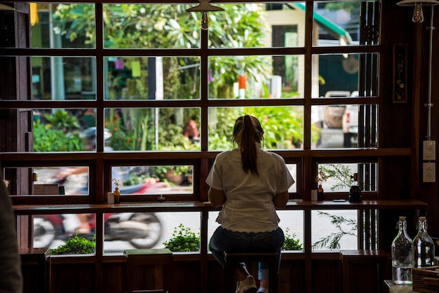 Una donna seduta al bar da sola si gode il suo dolce caffè.