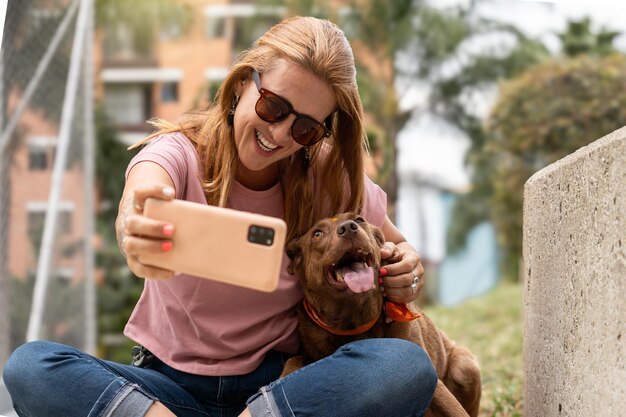 Una donna si fa un selfie con il suo cane all'aperto