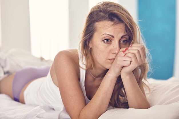 Una donna si preoccupa per qualcosa la mattina a letto