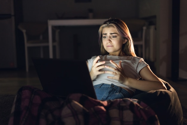 Una donna si siede a casa di notte e guarda un film