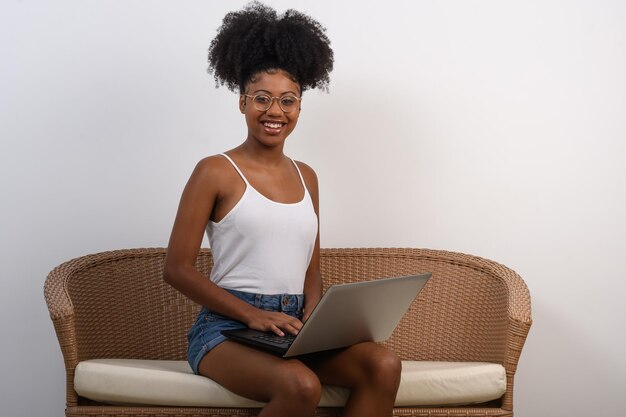 Una donna si siede su un divano con un computer portatile