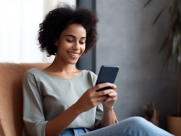 Una donna si siede su un divano e guarda il suo telefono.