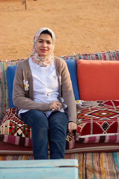 Una donna si siede su un divano nel deserto.