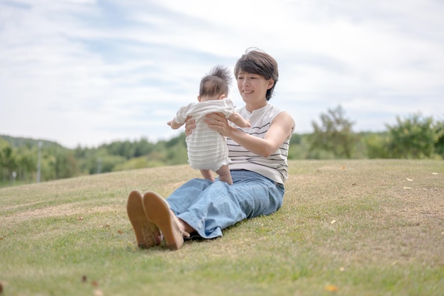 Una donna siede sull'erba con il suo bambino