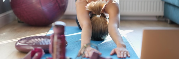 Una donna snella sta facendo stretching sul pavimento