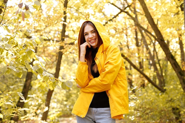 Una donna sorride su uno sfondo autunnale giallo