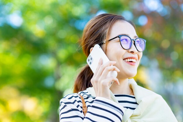 Una donna sorridente che parla su uno smartphone all'aperto