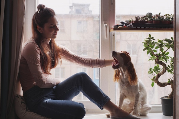 Una donna sorridente con un cane seduta a casa