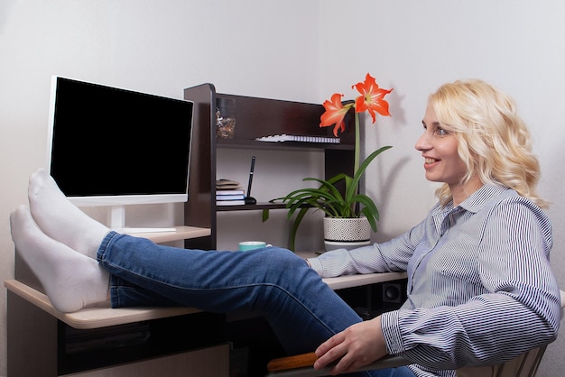 Una donna sorridente lavora a casa al computer Lavoro freelance