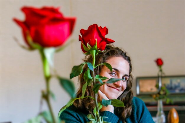 Una donna sorridente seduta dietro le rose