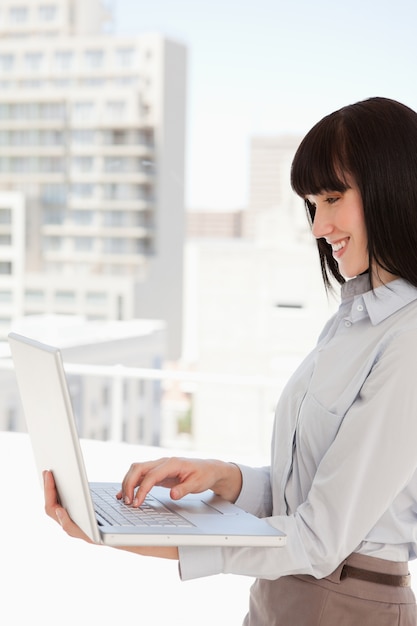 Una donna sorridente usa il suo portatile al lavoro