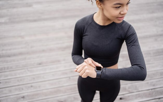 Una donna sportiva usa un tracker sulla sua mano smartwatch per lo sport