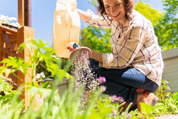 Una donna sta facendo giardinaggio nel suo cortile e pianta piantine