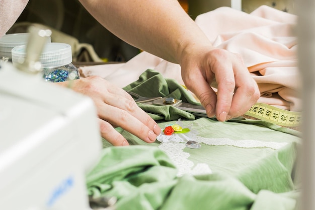 Una donna sta facendo gioielli un laboratorio domestico Mani femminili che creano un accessorio con perline