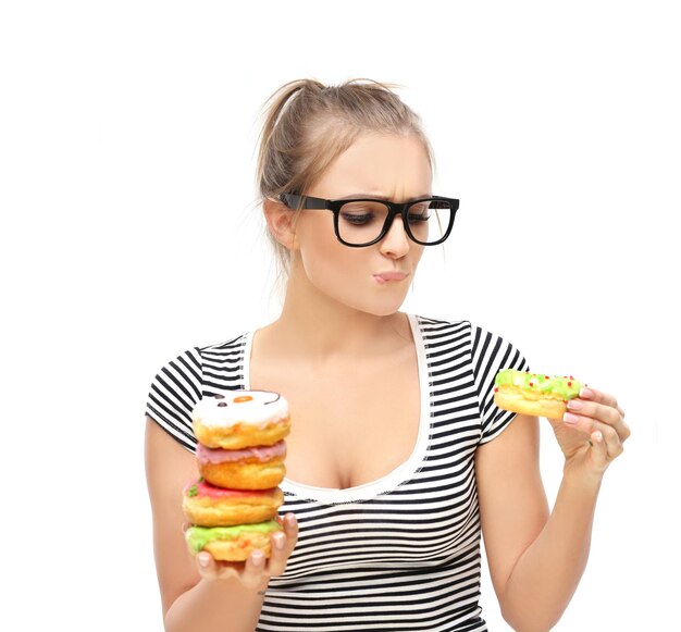 Una donna sta mangiando una ciambella con dei granelli sopra