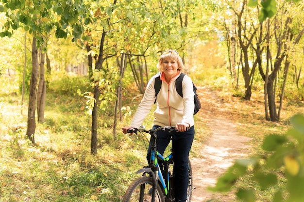 Una donna su una bicicletta percorre la strada nel parco cittadino