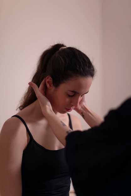 Una donna terapista esamina il collo della sua paziente