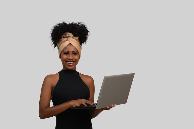 Una donna tiene in mano un computer portatile e sorride.