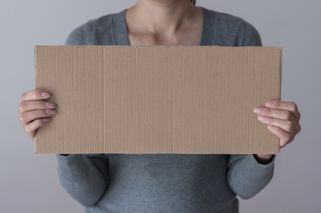 Una donna tiene un segno in bianco davanti al viso