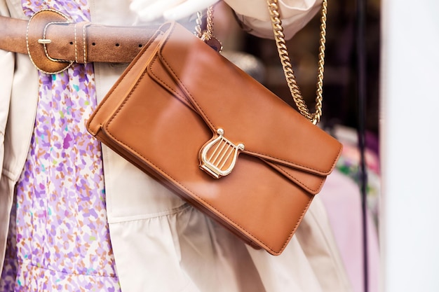 Una donna tiene una borsa con una fibbia d'oro e una catena d'oro.