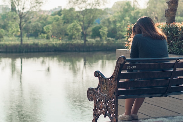 Una donna triste, sconvolta e preoccupata che si siede da solo all&#39;aperto