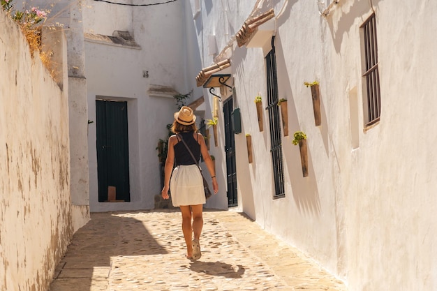 Una donna turistica che cammina attraverso le case bianche di Vejer de la Frontera Cadice Andalusia