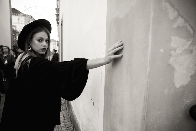 Una donna turistica felice che indossa un cappello nero si affaccia sulla colorata città vecchia del Portogallo