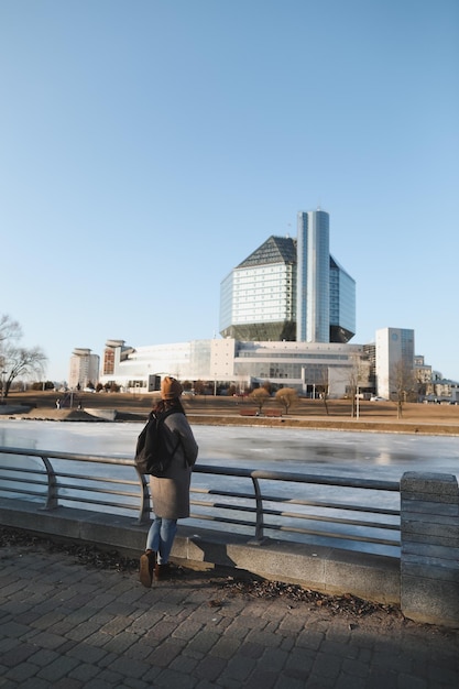 Una donna turistica gode della vista del paesaggio urbano della biblioteca nazionale della bielorussia a minsk durante il periodo primaverile