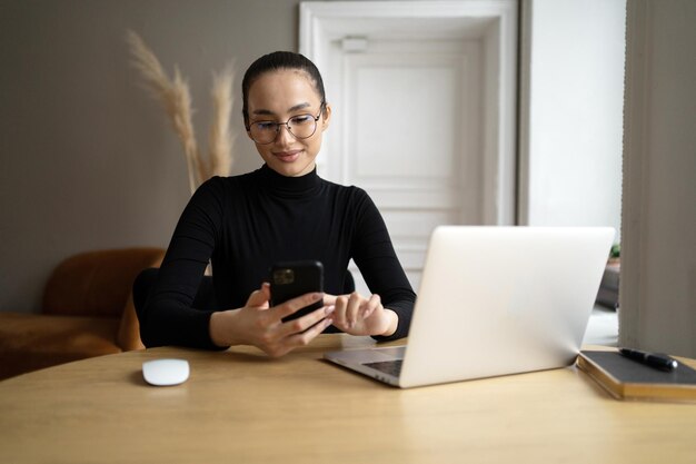 Una donna usa un computer portatile in ufficio scrive un messaggio a un collega