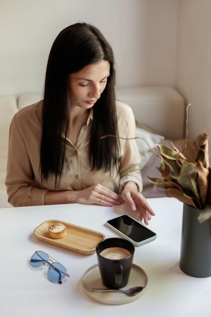 Una donna usa uno smartphone in un bar Blogger freelance