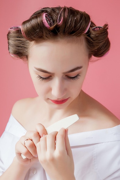 Una donna vestita di bianco tiene in mano un pezzo di carta.