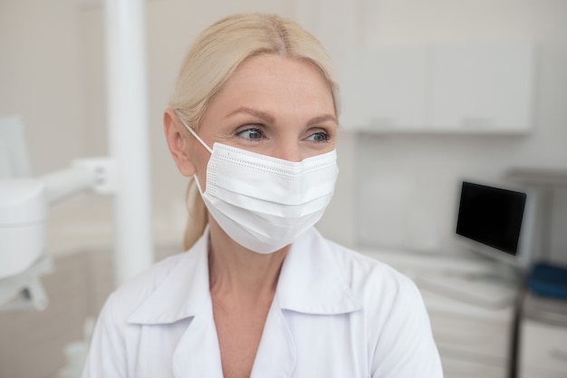 Una dottoressa bionda che indossa una maschera protettiva