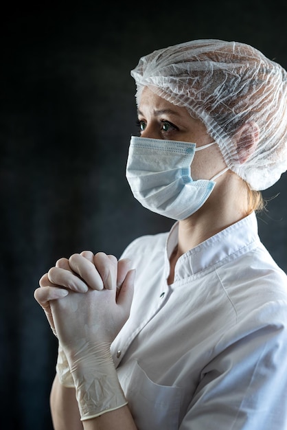 Una dottoressa caucasica stanca sta pregando in ospedale.