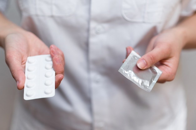 Una dottoressa in camice bianco offre una scelta di contraccettivi