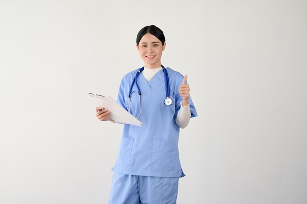 Una dottoressa in camice che mostra il pollice in alto e tiene in mano una lavagna per appunti medica