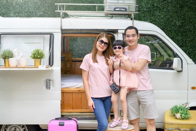 Una famiglia asiatica gioiosa che gode del viaggio e del viaggio su strada sta andando in vacanza, viaggi e concetto di turismo