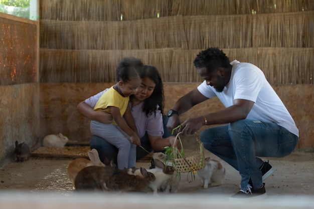 Una famiglia asiatico-africana americana si riposa in vacanza portando i bambini allo zoo