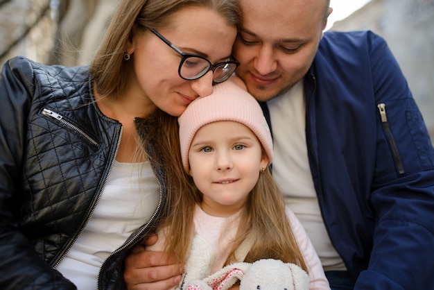 Una famiglia con una figlia si abbraccia e si diverte insieme.